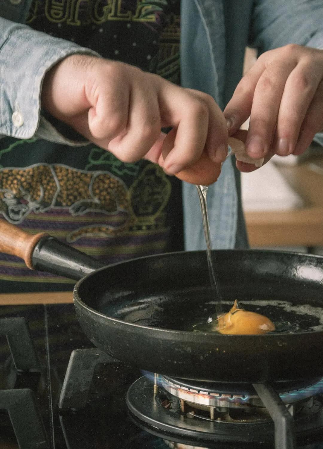 In einer Pfanne wird ein Ei aufgeschlagen – Frühstück bei Best Break